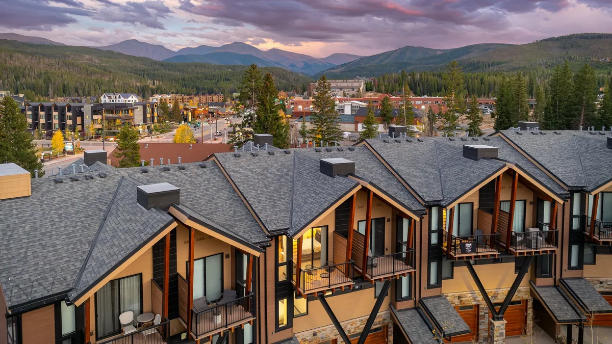 A wide-angle exterior shot that captures the property’s balconies overlooking the Winter Park town skyline with mountain ranges in the distance. The scene hints at easy access to both the vibrant town center and scenic outdoor adventures.